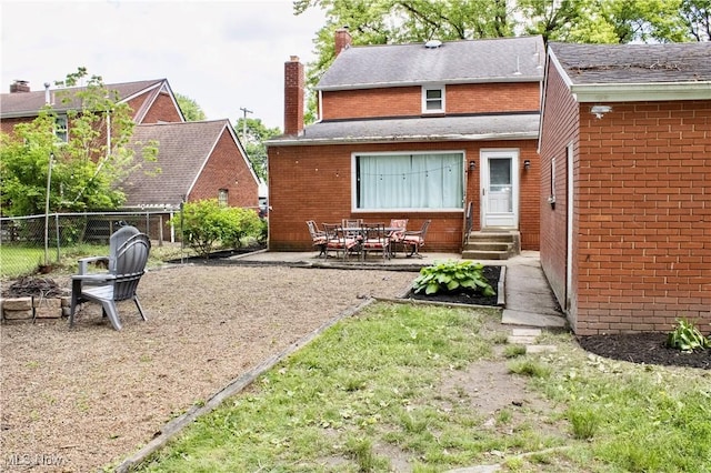 6892 Glenwood Ave, Youngstown, OH 44512 - back of house with entry steps, a chimney, brick siding, and a patio