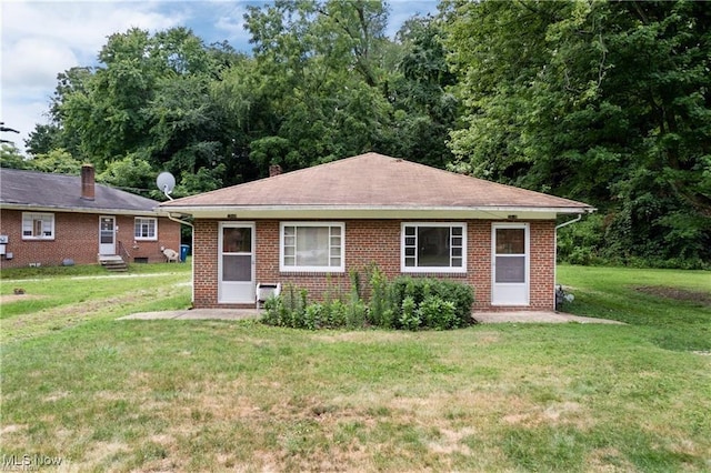 594 Shook Rd, Coventry, OH 44319 - view of front of house featuring a front yard, brick siding, entry steps, and roof with shingles