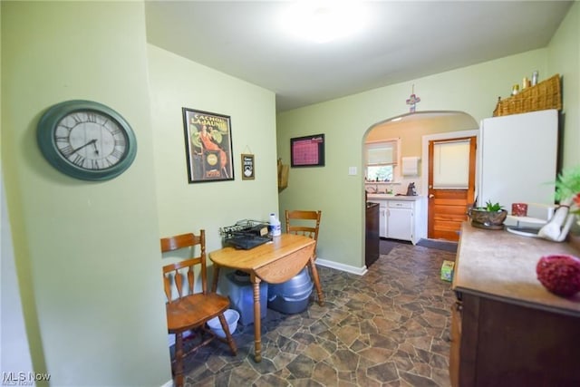 3000AND2996 Kemble Ave, Coventry, OH 44319 - dining room featuring arched walkways, stone flooring, and baseboards