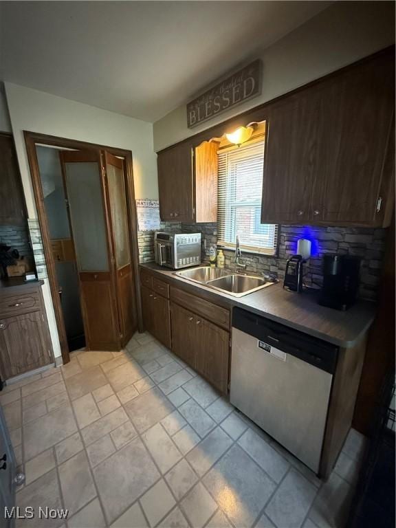 7511 Jameson Rd, Parma, OH 44129 - kitchen featuring stainless steel dishwasher, a sink, backsplash, and dark countertops