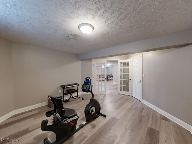 8836 Shetland Ct, Kirtland, OH 44094 - workout room featuring french doors, wood finished floors, baseboards, and a textured ceiling