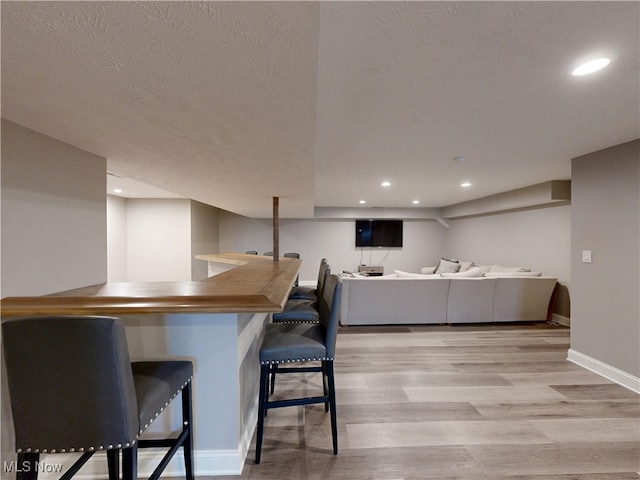 8836 Shetland Ct, Kirtland, OH 44094 - indoor bar with light wood-style flooring, recessed lighting, a textured ceiling, and baseboards