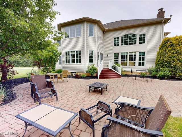 8836 Shetland Ct, Kirtland, OH 44094 - back of property with an outdoor fire pit, a patio area, and a chimney