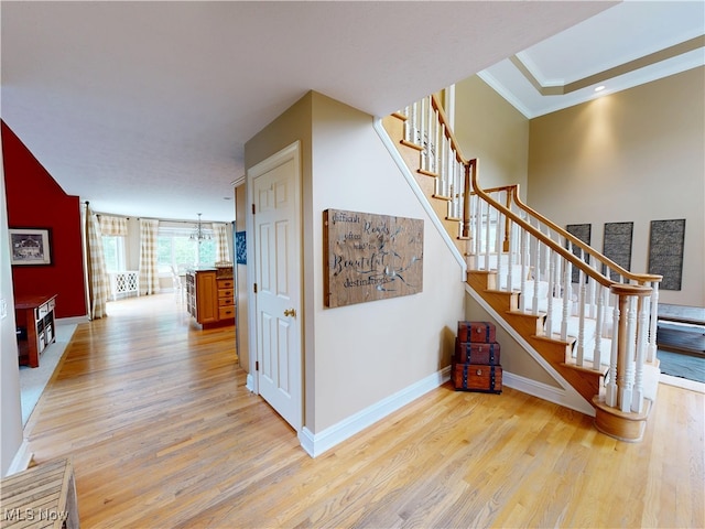 8836 Shetland Ct, Kirtland, OH 44094 - stairs featuring wood finished floors, a chandelier, baseboards, and crown molding
