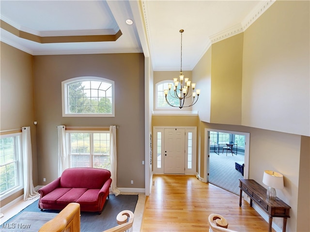 8836 Shetland Ct, Kirtland, OH 44094 - foyer entrance featuring crown molding, a towering ceiling, light wood-type flooring, a chandelier, and baseboards