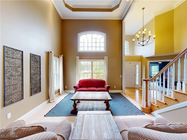 8836 Shetland Ct, Kirtland, OH 44094 - living area featuring a chandelier, a towering ceiling, ornamental molding, baseboards, and stairs