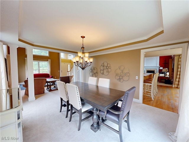 8836 Shetland Ct, Kirtland, OH 44094 - dining room with light colored carpet, a raised ceiling, ornate columns, crown molding, and a chandelier