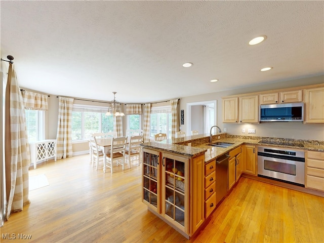 8836 Shetland Ct, Kirtland, OH 44094 - kitchen featuring stainless steel appliances, a sink, light wood-style floors, a peninsula, and recessed lighting
