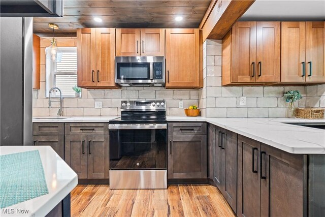 4493 Golfway Rd, South Euclid, OH 44121 - kitchen with stainless steel appliances, a sink, light wood finished floors, and decorative backsplash