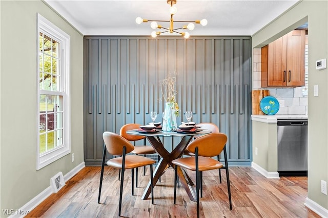 4493 Golfway Rd, South Euclid, OH 44121 - dining space featuring a chandelier, light wood-style flooring, and baseboards
