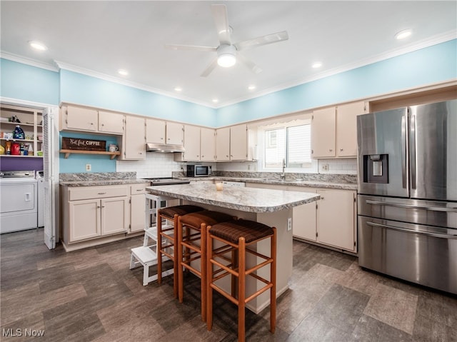 154 Montgomery Blvd, New Concord, OH 43762 - kitchen featuring appliances with stainless steel finishes, under cabinet range hood, washing machine and clothes dryer, ornamental molding, and a sink