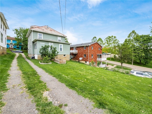 154 Montgomery Blvd, New Concord, OH 43762 - back of house featuring a lawn and driveway