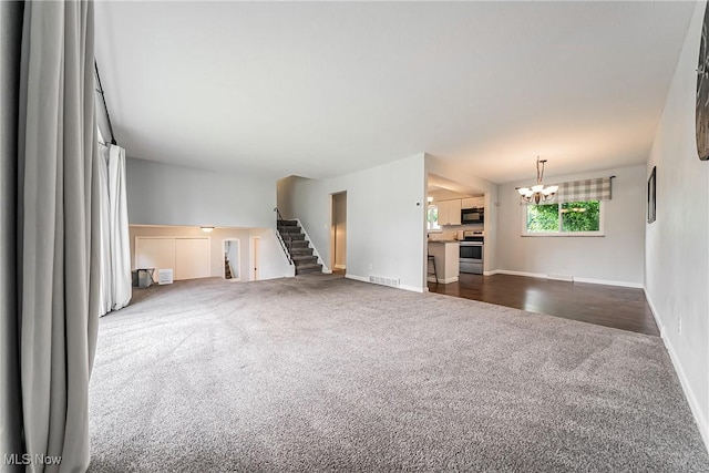 21517 Nottingham Dr, Fairview Park, OH 44126 - unfurnished living room featuring dark carpet, a chandelier, baseboards, and stairway