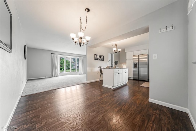 21517 Nottingham Dr, Fairview Park, OH 44126 - unfurnished living room with a chandelier, dark wood-type flooring, and baseboards