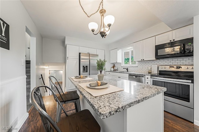 21517 Nottingham Dr, Fairview Park, OH 44126 - kitchen featuring stainless steel appliances, backsplash, dark wood finished floors, and white cabinets