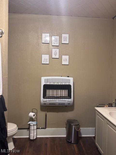 419 Commerce St, Wellsburg, WV 26070 - bathroom with heating unit, wood finished floors, toilet, vanity, and baseboards