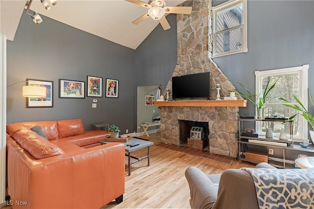 7170 Lafayette Rd, Medina, OH 44256 - living area featuring high vaulted ceiling, ceiling fan, wood finished floors, a stone fireplace, and track lighting