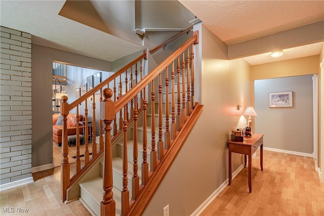 7170 Lafayette Rd, Medina, OH 44256 - stairway featuring a textured ceiling, wood finished floors, and baseboards