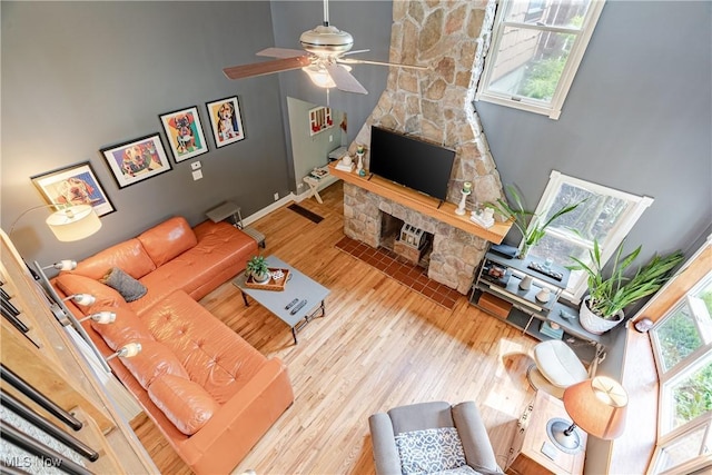 7170 Lafayette Rd, Medina, OH 44256 - living room with wood finished floors, a ceiling fan, a fireplace, and a towering ceiling