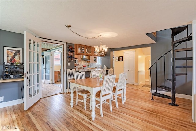 7170 Lafayette Rd, Medina, OH 44256 - dining area featuring light wood-type flooring, a chandelier, stairs, and baseboards