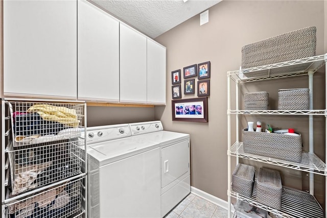 1955 Wendover Cir NE, North Canton, OH 44720 - laundry area featuring washer and clothes dryer, cabinet space, baseboards, light tile patterned flooring, and a textured ceiling