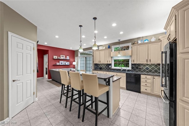 1955 Wendover Cir NE, North Canton, OH 44720 - kitchen with black appliances, cream cabinets, a sink, backsplash, and a breakfast bar