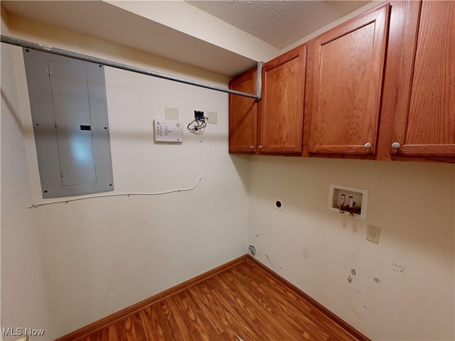 809 Fiddlers Crk, Painesville, OH 44077 - washroom featuring cabinet space, electric panel, hookup for a washing machine, hookup for an electric dryer, and wood finished floors