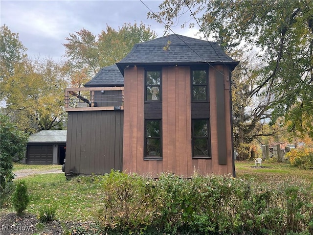 405 Bliss Ave, Conneaut, OH 44030 - view of home's exterior with roof with shingles, a detached garage, an outdoor structure, and driveway