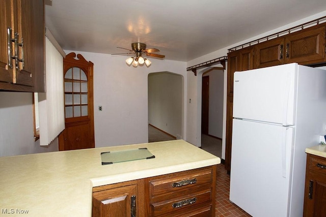 430 W Harvey St, Struthers, OH 44471 - kitchen featuring freestanding refrigerator, light countertops, a ceiling fan, brick patterned floors, and arched walkways