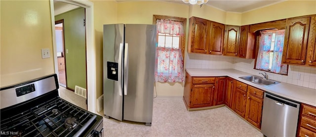 104 Sunnycliff Dr, Euclid, OH 44123 - kitchen featuring appliances with stainless steel finishes, a sink, crown molding, healthy amount of natural light, and brown cabinets