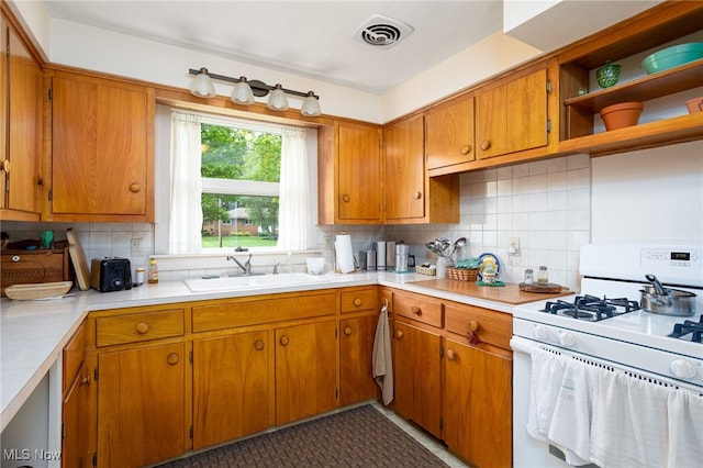 125 Beech St, Doylestown, OH 44230 - kitchen with white gas range, decorative backsplash, light countertops, and a sink