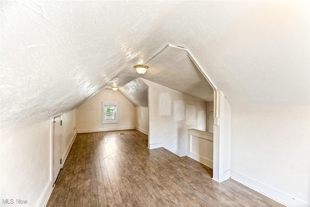 916 Kling St, Akron, OH 44311 - additional living space featuring lofted ceiling, wood finished floors, a textured ceiling, and baseboards