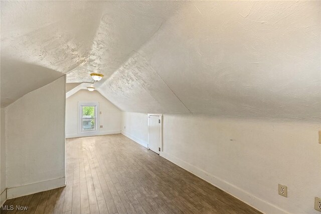 916 Kling St, Akron, OH 44311 - additional living space featuring baseboards, vaulted ceiling, wood finished floors, and a textured ceiling
