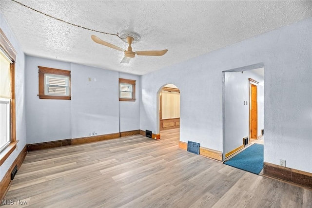 916 Kling St, Akron, OH 44311 - unfurnished room with arched walkways, wood finished floors, ceiling fan, baseboards, and a textured ceiling