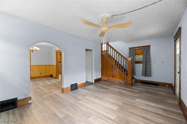 916 Kling St, Akron, OH 44311 - empty room with wood finished floors, arched walkways, a ceiling fan, a textured ceiling, and baseboards