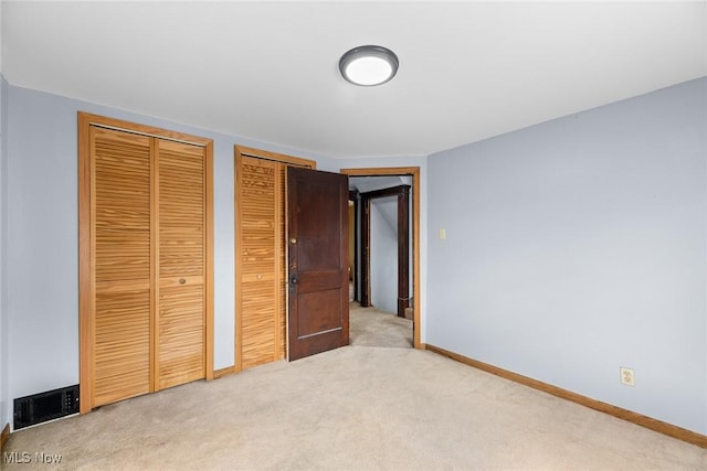 916 Kling St, Akron, OH 44311 - unfurnished bedroom with multiple closets, light colored carpet, and baseboards