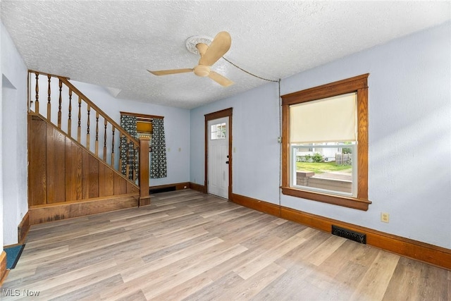 916 Kling St, Akron, OH 44311 - foyer entrance featuring wood finished floors, baseboards, stairway, a textured ceiling, and ceiling fan