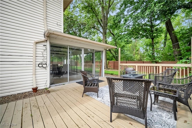 5512 Berkshire Dr, North Olmsted, OH 44070 - deck with outdoor dining area, a sunroom, and view of wooded area