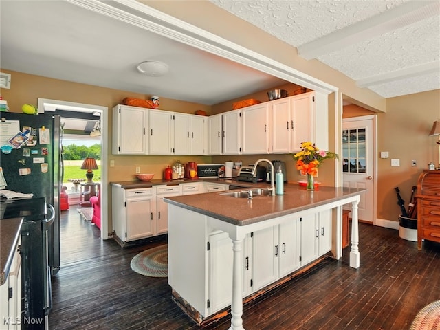 4300 Wade Ave, Ashtabula, OH 44004 - kitchen featuring dark wood finished floors, white cabinets, a peninsula, beam ceiling, and a textured ceiling