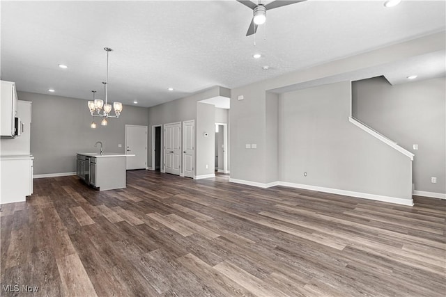 360 Bascule Dr, Lorain, OH 44052 - unfurnished living room featuring dark wood-style flooring, ceiling fan, recessed lighting, and a chandelier