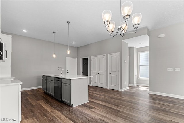 360 Bascule Dr, Lorain, OH 44052 - kitchen with dark wood finished floors, light countertops, dishwasher, a chandelier, and hanging light fixtures