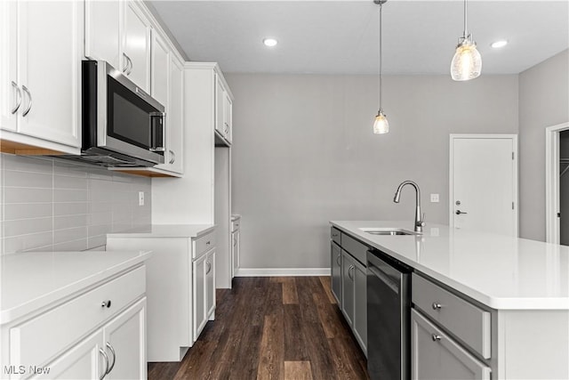 360 Bascule Dr, Lorain, OH 44052 - kitchen with stainless steel appliances, tasteful backsplash, light countertops, dark wood-style floors, and pendant lighting