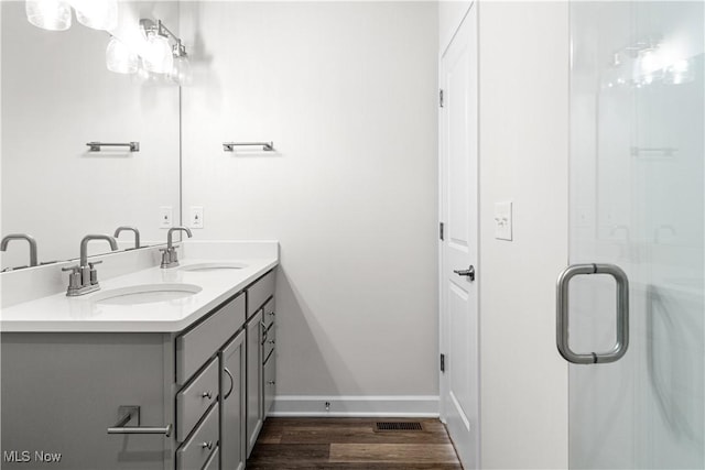 360 Bascule Dr, Lorain, OH 44052 - bathroom featuring double vanity, wood finished floors, and a shower with door