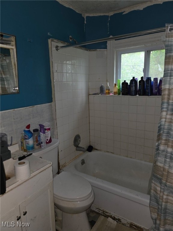 121 Parkview Ct, Elyria, OH 44035 - full bathroom featuring tile walls, toilet, vanity, shower / bath combination with curtain, and a wainscoted wall