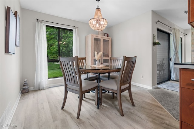 6290 Greenwood Pkwy Unit 402, Northfield, OH 44067 - dining room featuring light wood-style flooring, a chandelier, and baseboards