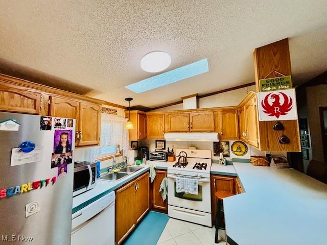 147 Northgate Dr NE, Warren, OH 44484 - kitchen featuring white appliances, under cabinet range hood, lofted ceiling, a skylight, and a textured ceiling