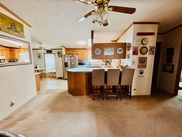 147 Northgate Dr NE, Warren, OH 44484 - kitchen featuring ceiling fan, stainless steel appliances, a peninsula, and light colored carpet