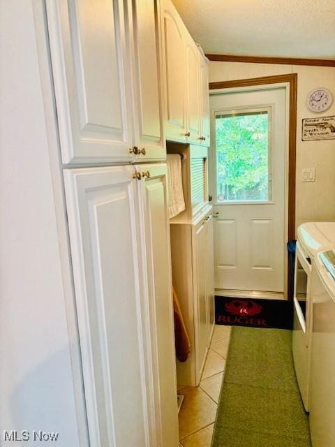 147 Northgate Dr NE, Warren, OH 44484 - laundry room with washing machine and clothes dryer, light tile patterned floors, cabinet space, a textured ceiling, and ornamental molding