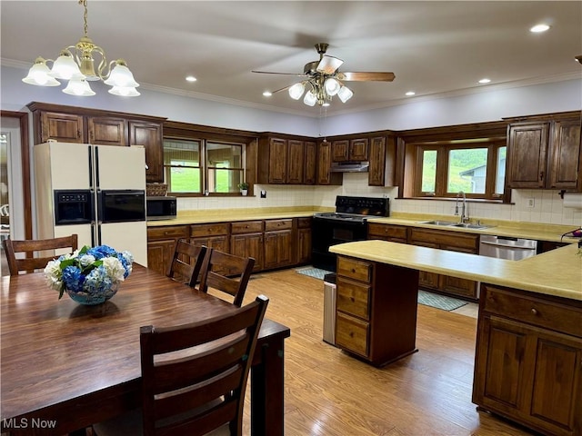 42096 Cadiz Dennison Rd, Cadiz, OH 43907 - kitchen with stainless steel appliances, a sink, under cabinet range hood, light countertops, and decorative backsplash