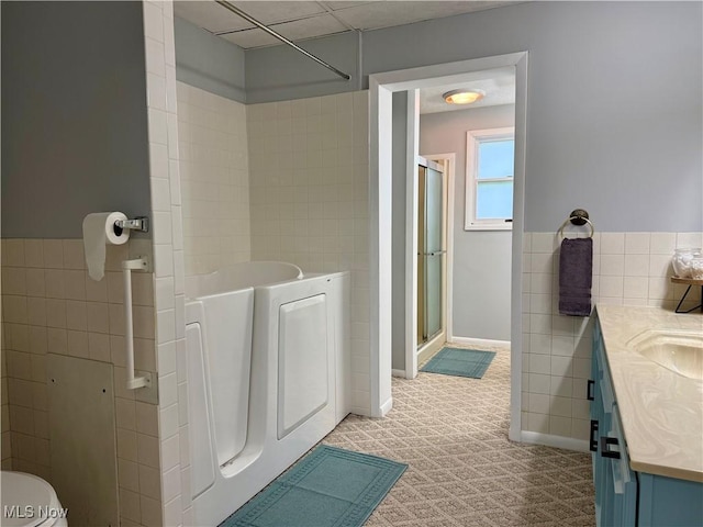 42096 Cadiz Dennison Rd, Cadiz, OH 43907 - full bathroom featuring a shower stall, vanity, tile walls, a bath, and toilet